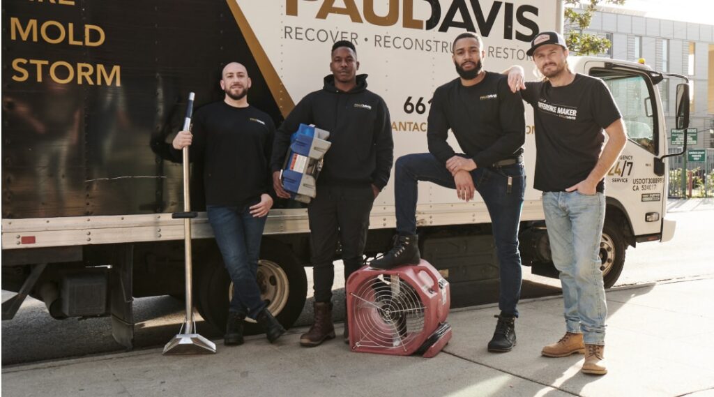 Paul Davis Restoration team in front of service truck with equipment, providing professional restoration services in Greater Seattle